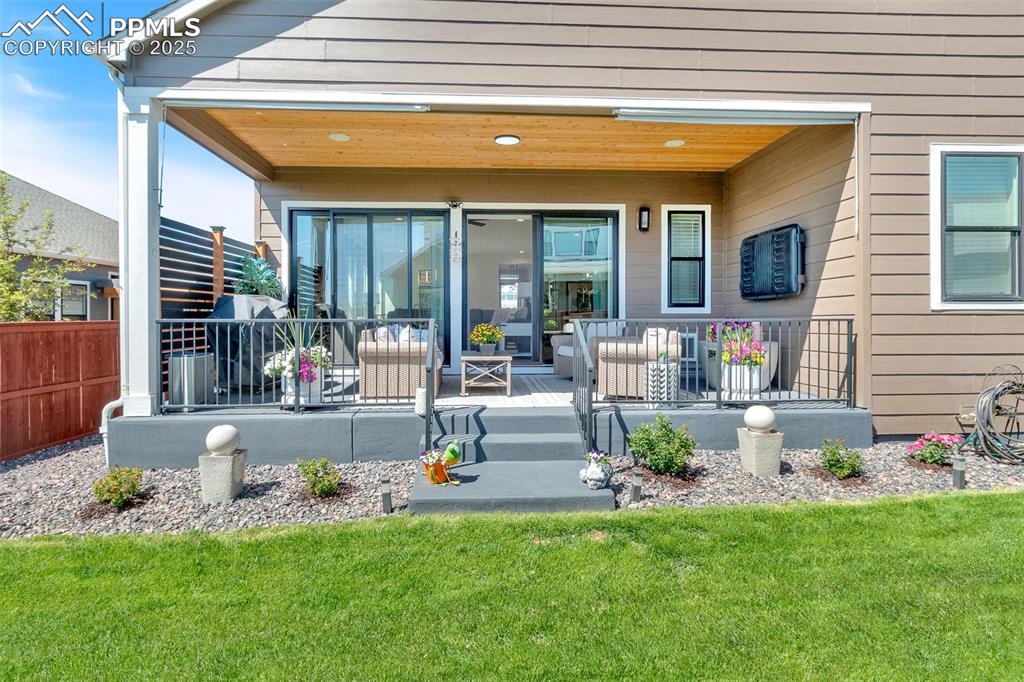 Image 6 of 48: Entrance to property featuring a deck and a lawn