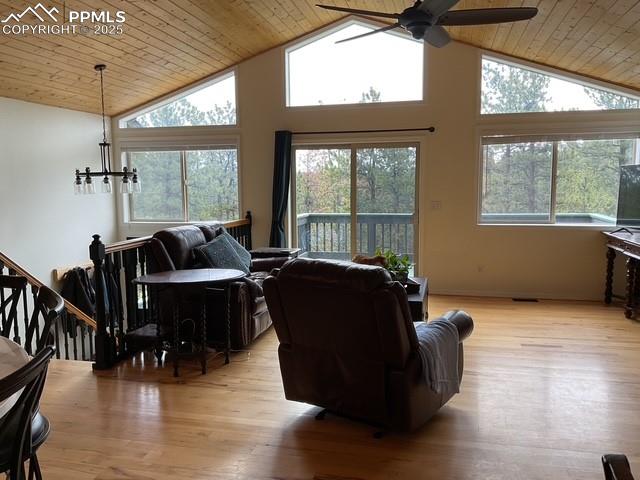 Image 21 of 39: Living room with vaulted ceiling, a ceiling fan, wooden ceiling, light wood