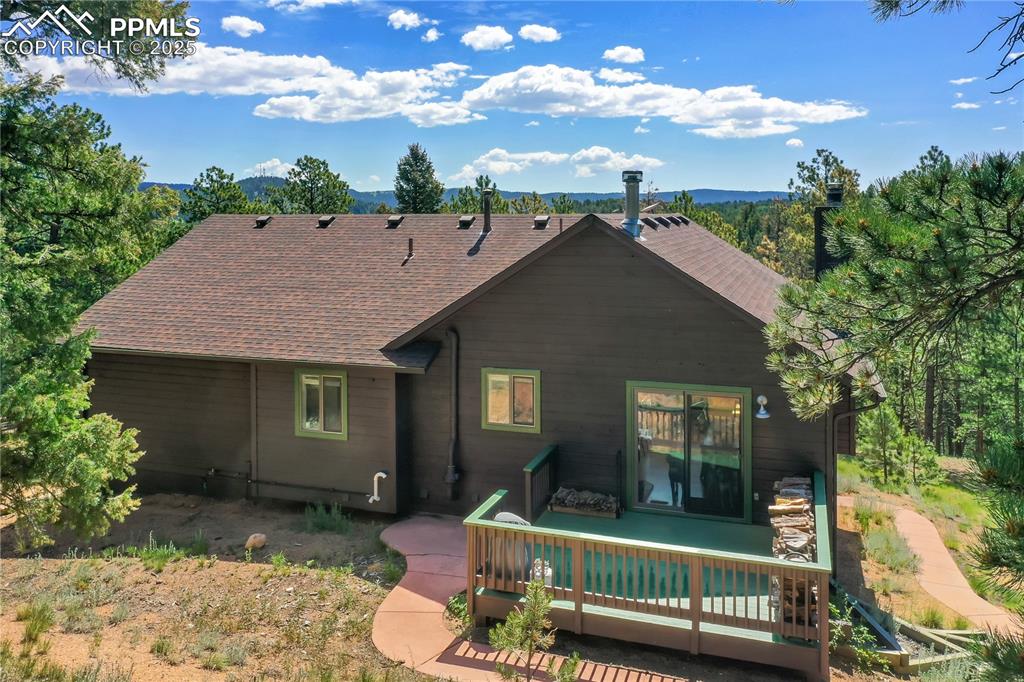 Image 3 of 39: Rear view of house featuring a deck with mountain view and roof with shingl