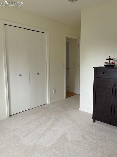 Image 32 of 39: 2nd bedroom featuring light colored carpet, baseboards, and a closet