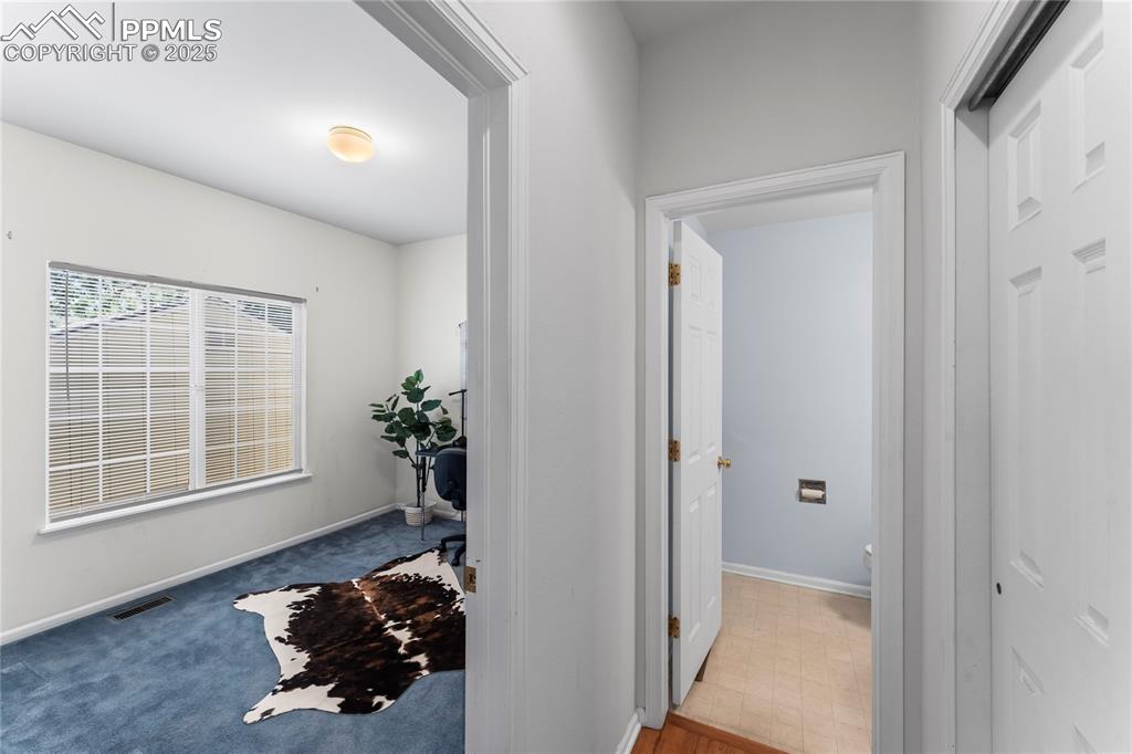 Image 21 of 49: Corridor with baseboards and light colored carpet
