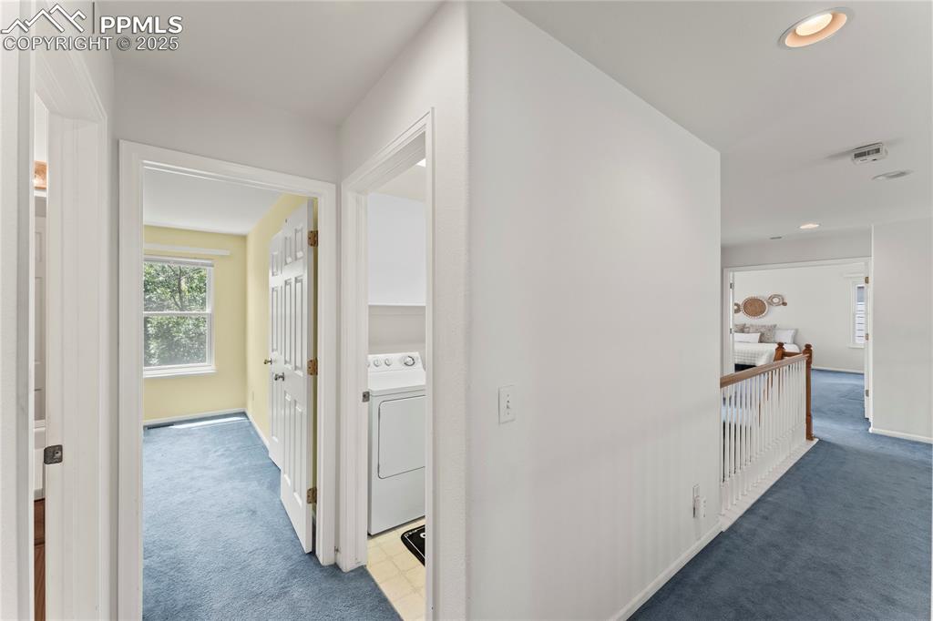 Image 26 of 49: Hall with carpet floors, washer / clothes dryer, plenty of natural light, a