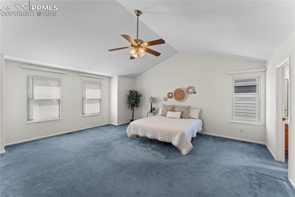 Image 33 of 49: Bedroom with lofted ceiling, carpet floors, and ceiling fan