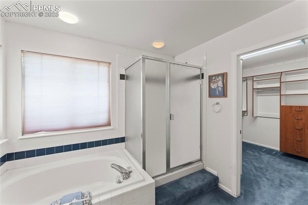 Image 38 of 49: Full bathroom with a shower stall and a bath