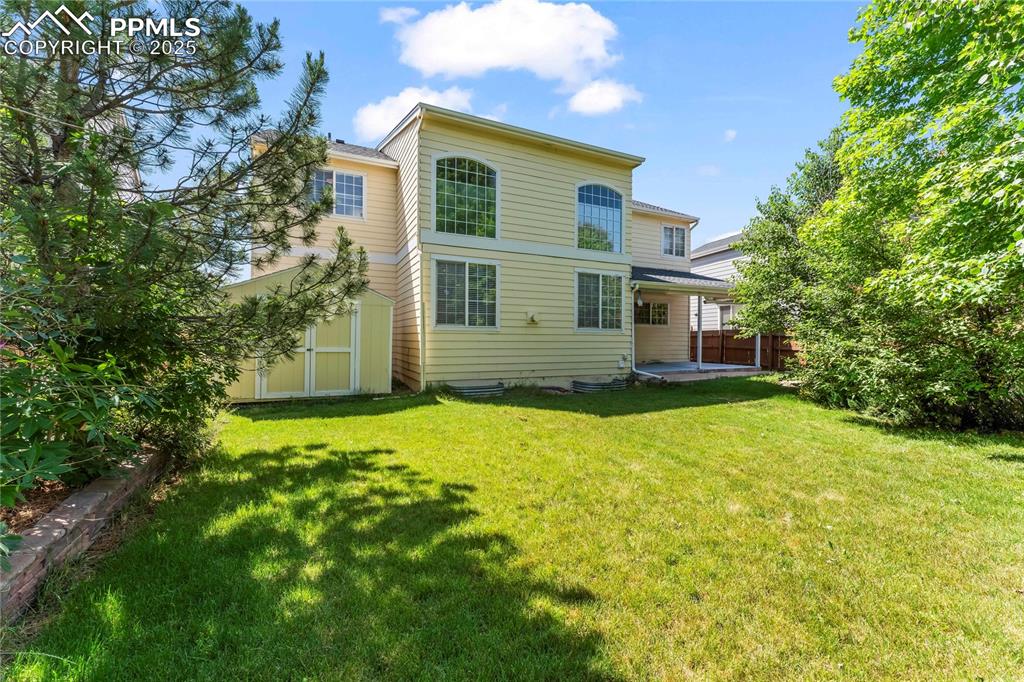 Image 48 of 49: Fenced yard with shed, patio and pond