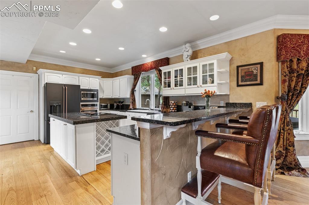 Image 12 of 50: Kitchen with a peninsula, appliances with stainless steel finishes, light w