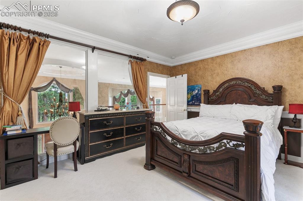 Image 24 of 50: Bedroom with light colored carpet and ornamental molding