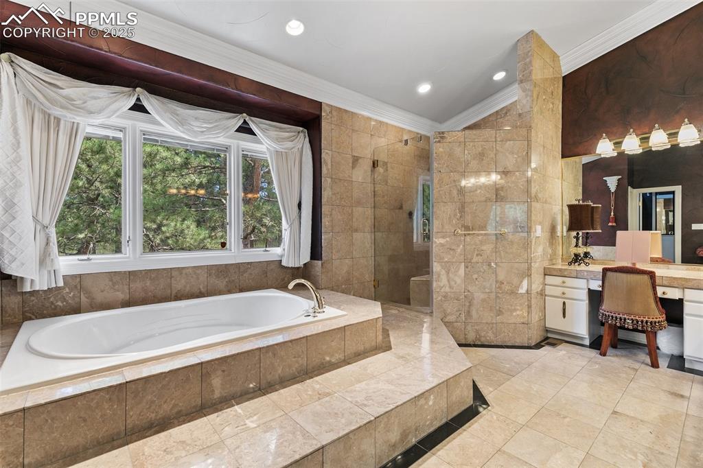 Image 32 of 50: Full bathroom featuring a garden tub, vanity, ornamental molding, tile wall