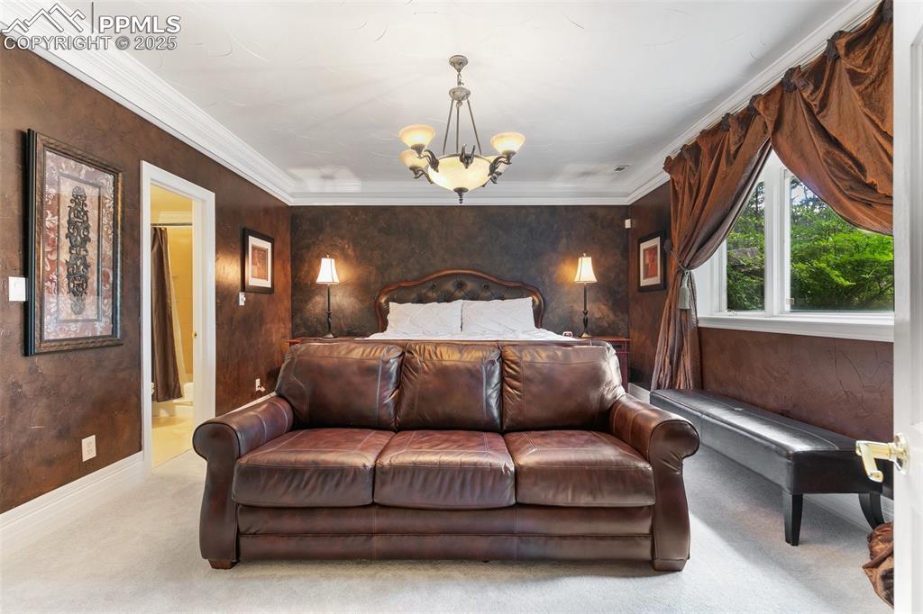 Image 36 of 50: Bedroom featuring a chandelier, carpet floors, crown molding, baseboards, a