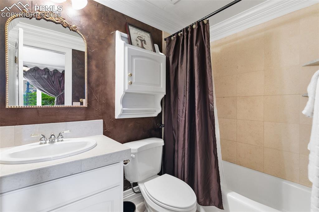 Image 37 of 50: Bathroom with vanity, toilet, and shower / tub combo with curtain