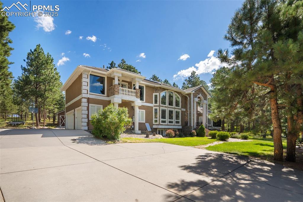 Image 4 of 50: View of front of home with a balcony,  driveway, an attached garage, a fron