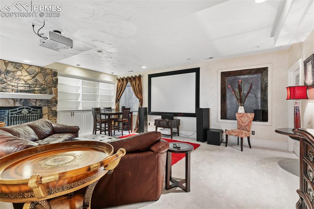 Image 42 of 50: Carpeted cinema featuring baseboards, a stone fireplace, and recessed light
