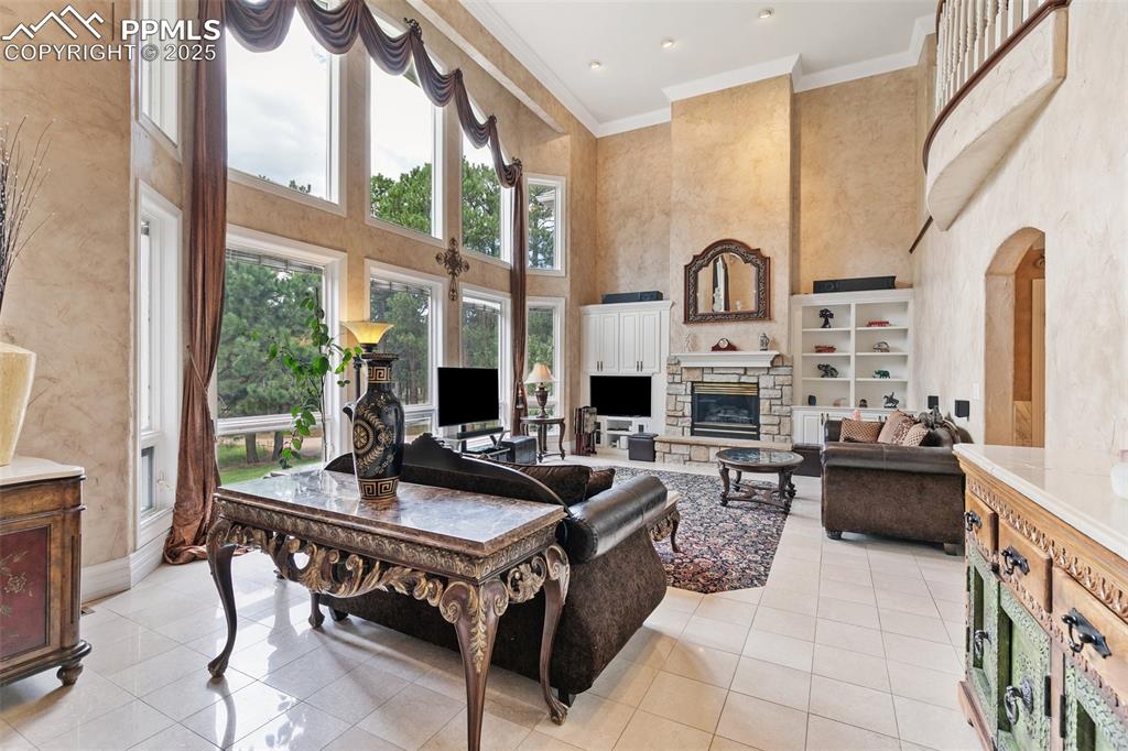 Image 6 of 50: Living room featuring a towering ceiling, light tile patterned flooring, cr