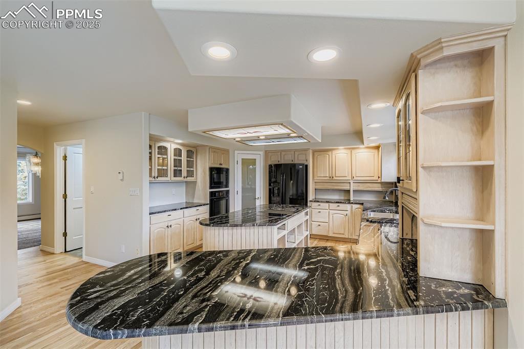 Image 12 of 35: Kitchen with open shelves, wood cabinets, recessed lighting, light wood ref