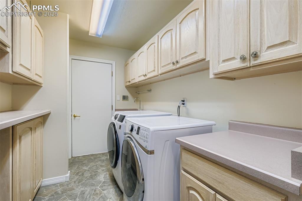 Image 17 of 35: Laundry room featuring washer and clothes dryer, cabinet space, and light s