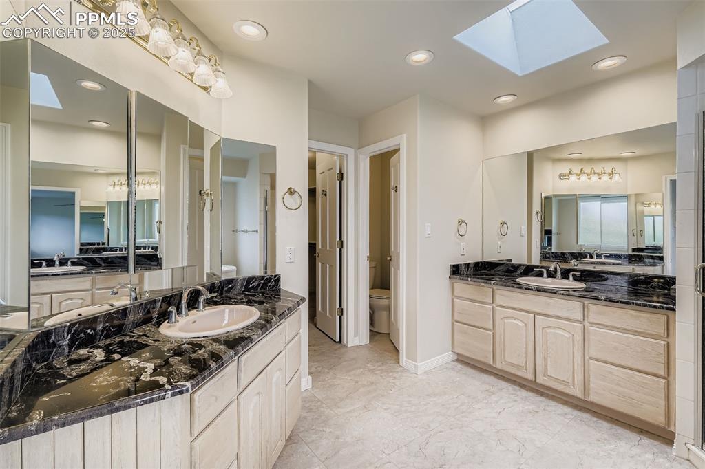Image 22 of 35: Bathroom with a skylight, two vanities, recessed lighting, and light, vinyl