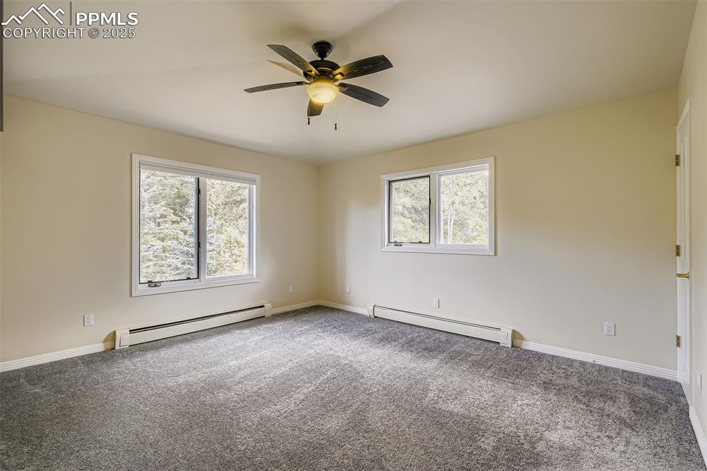 Image 27 of 35: Bedroom featuring multiple windows, new carpet, and a ceiling fan, ensuite