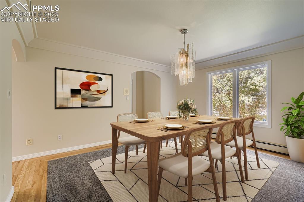 Image 6 of 35: Virtually Staged! Formal dining room with arched walkways, light wood-style