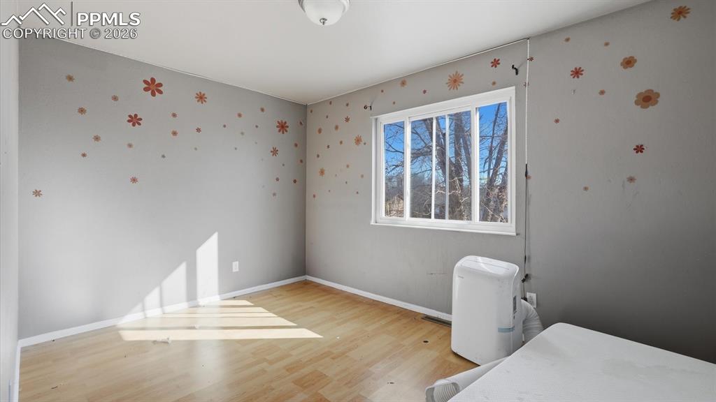 Image 12 of 30: Upper Level Primary Bedroom with wood laminate floor.
