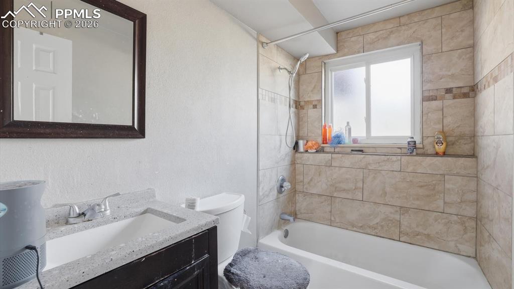 Image 20 of 30: Lower Level Bedroom #3 includes a vanity, framed mirror, and tiled tub/show