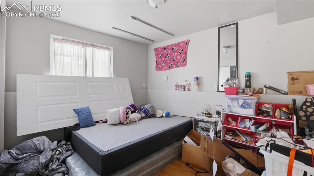 Image 21 of 30: Lower Level Bedroom #4 has wood laminate flooring and a window.