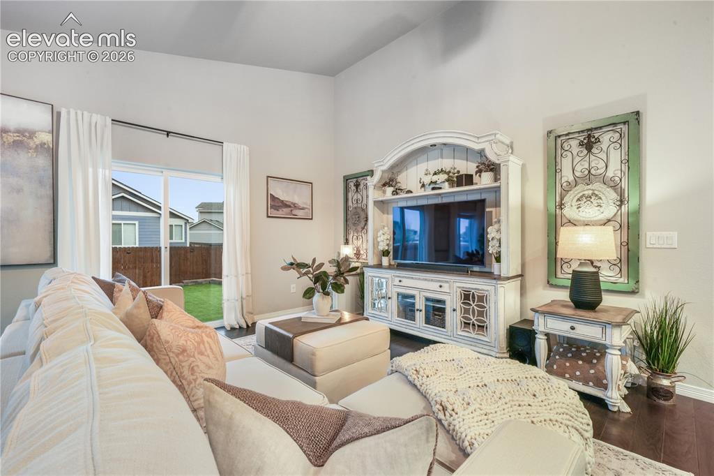 Image 12 of 50: Spacious interior with vaulted ceilings, rich wood-finish flooring, and a s