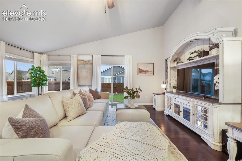 Image 13 of 50: Vaulted ceilings, large windows, dark wood-finish flooring, built-in entert