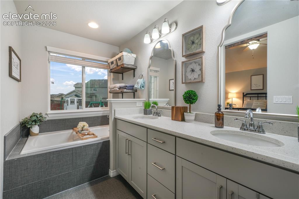 Image 17 of 50: Dual vanity with integrated sinks, light gray cabinetry, and light-toned co