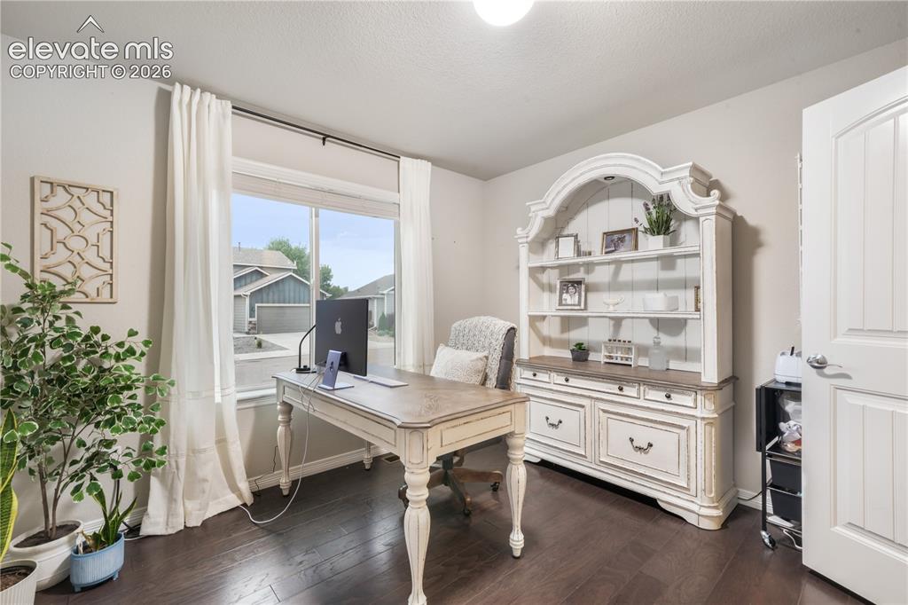 Image 20 of 50: Hardwood-style flooring, white trim, and a large window with natural light