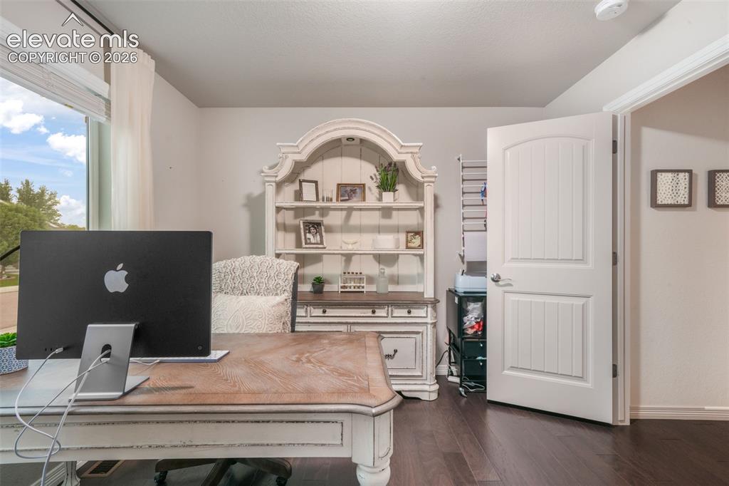Image 22 of 50: Hardwood flooring, painted interior door, window with white blinds, light w