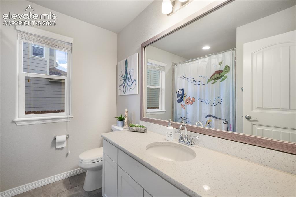 Image 24 of 50: White vanity with integrated sink, speckled countertop, and chrome faucet