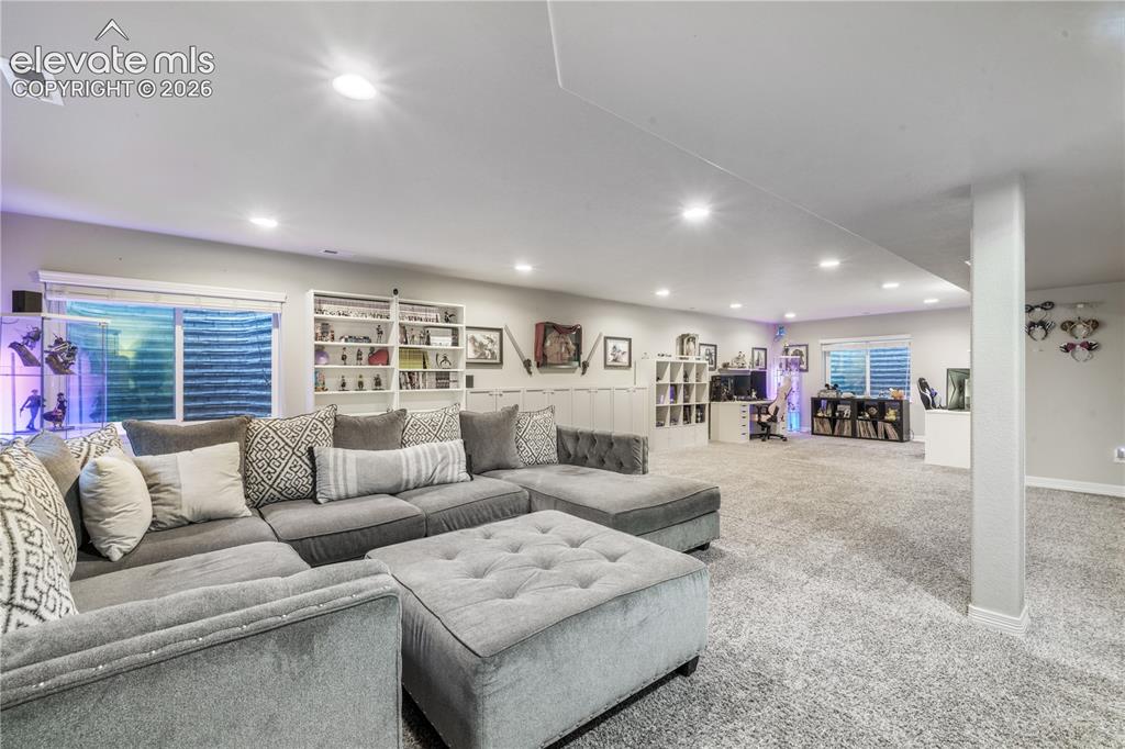 Image 27 of 50: Spacious finished basement with recessed lighting, carpet flooring, built-i