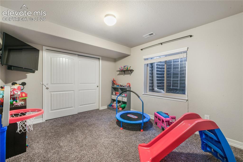 Image 31 of 50: Carpeted floor, sliding barn-style closet doors, recessed window, and flush
