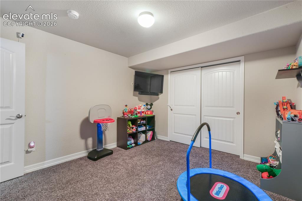 Image 33 of 50: Carpeted room featuring a white door, white sliding closet doors, and a cei