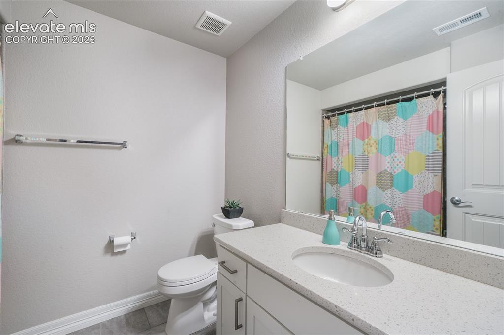 Image 34 of 50: White vanity with brushed nickel hardware, integrated sink, and a speckled 