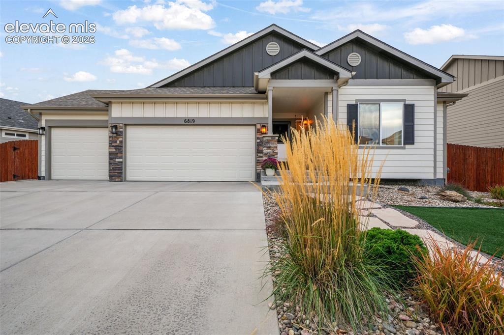 Image 44 of 50: Exterior featuring a two-car garage, stone accents, and a covered entry