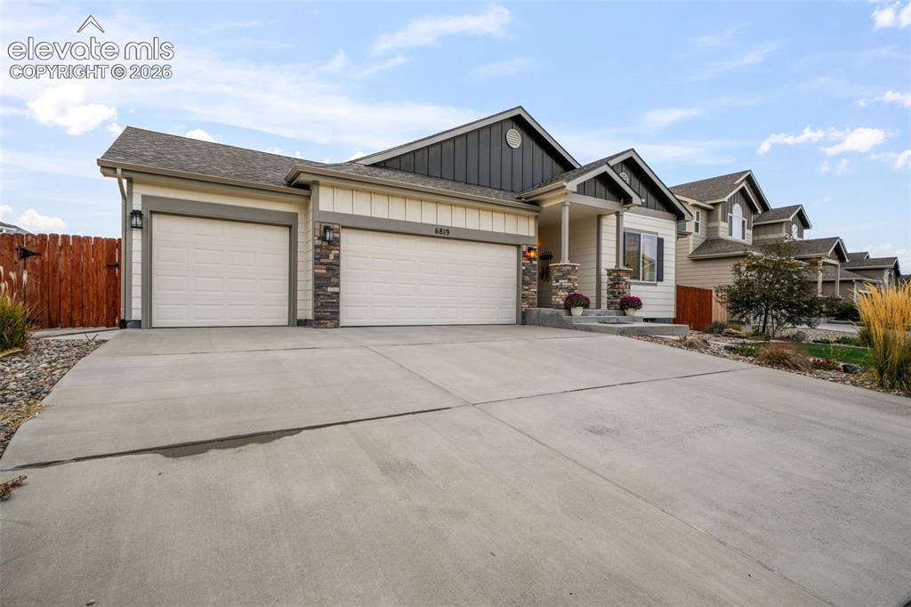 Image 45 of 50: Ranch-style exterior featuring a concrete driveway, attached garage, and st