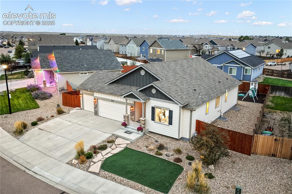 Image 46 of 50: Two-car garage, stone accents, concrete driveway, front yard landscaping wi
