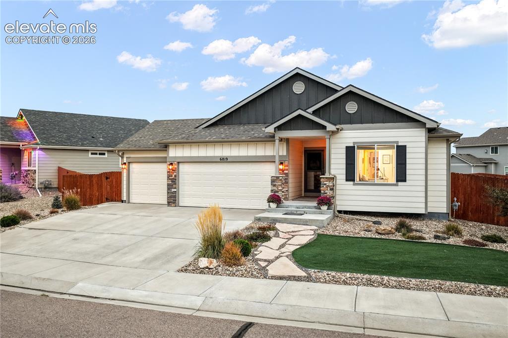 Image 47 of 50: Exterior featuring a stone-accented facade, attached two-car garage, concre