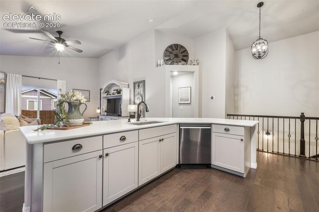 Image 6 of 50: Kitchen island with white cabinetry, stainless steel dishwasher, and a sing