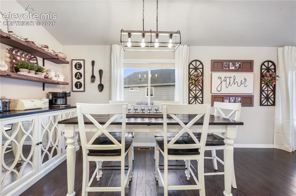 Image 9 of 50: Hardwood-finish flooring, built-in open shelving, and a decorative light fi