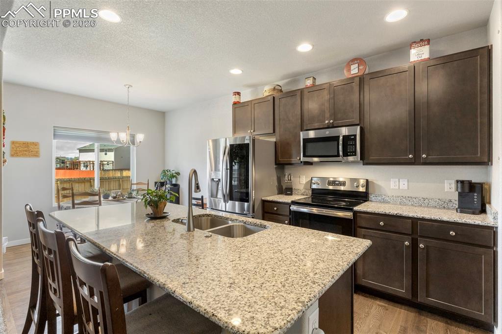Image 8 of 28: The well-equipped kitchen features a spacious granite island with breakfast