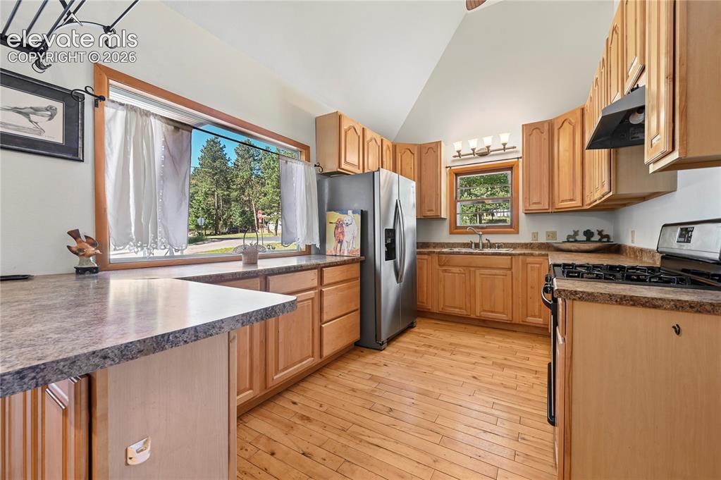 Image 11 of 45: Nice-size main level kitchen with gas range, full sized fridge, and a great