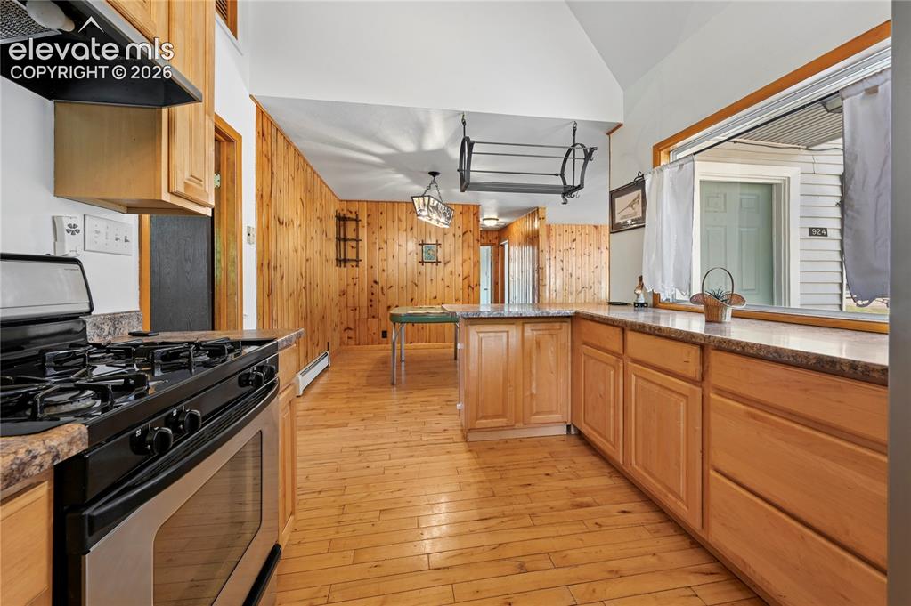 Image 12 of 45: Kitchen with hanging pot rack and plenty of counter space and the adjoining