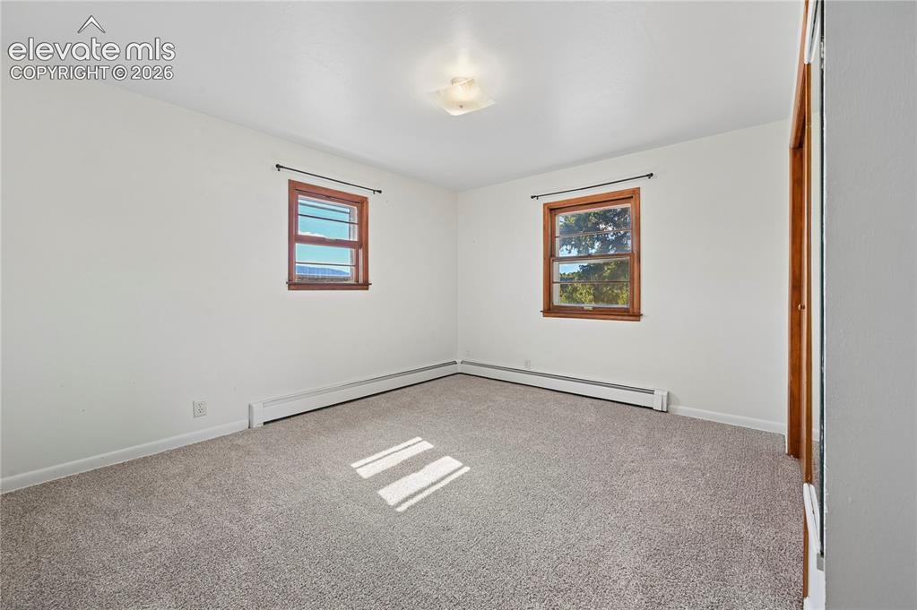 Image 16 of 45: Bedroom #2 of 4 is on the main level with new carpeting and bright paint