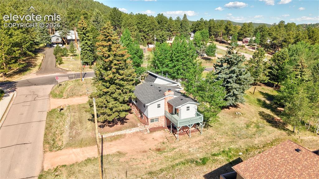 Image 39 of 45: Side yard showing basement entrance and primary bedroom balcony deck