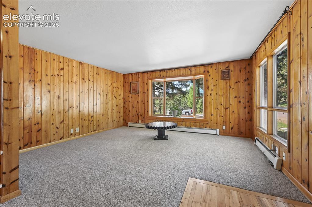 Image 5 of 45: Main level entrance and spacious living room with brand new carpeting and s