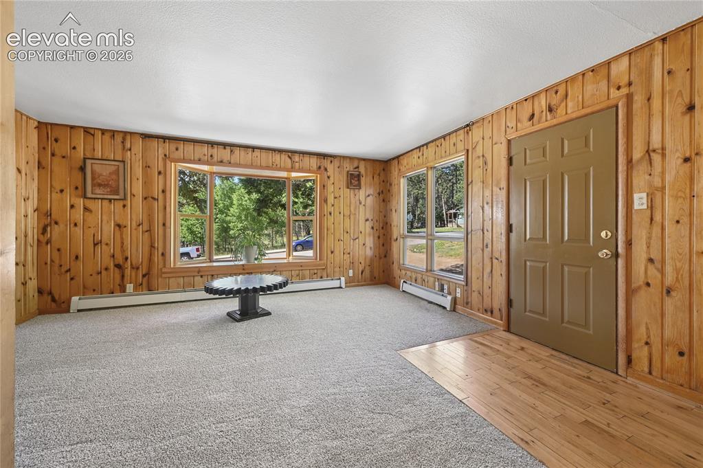 Image 6 of 45: Main level entrance and spacious living room with brand new carpeting and s