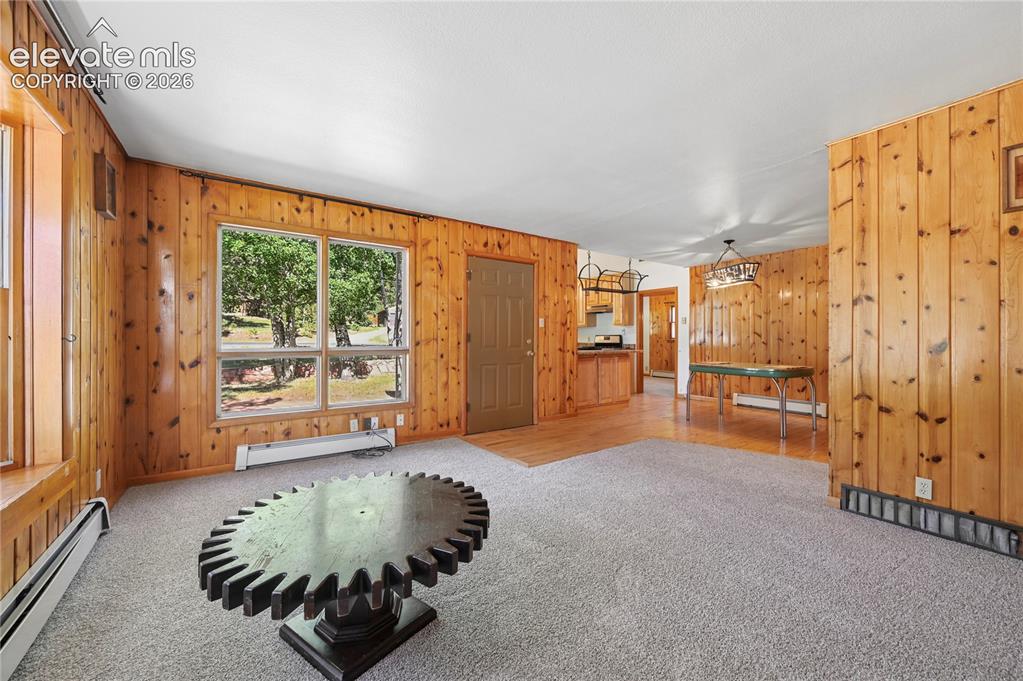Image 7 of 45: Main level living room with adjacent dining area leading to kitchen