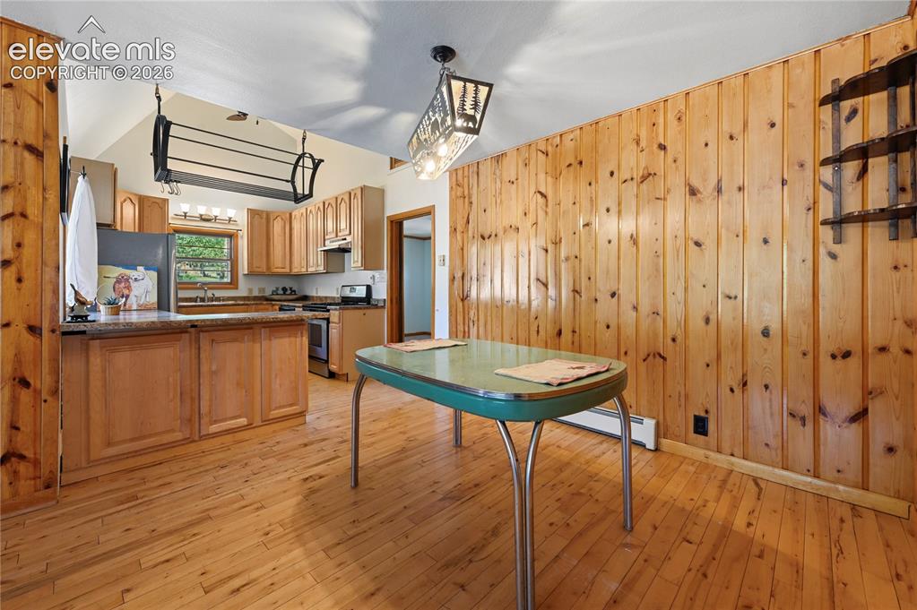 Image 9 of 45: Wood-filled dining room adjoins the kitchen, with a serving counter/ breakf